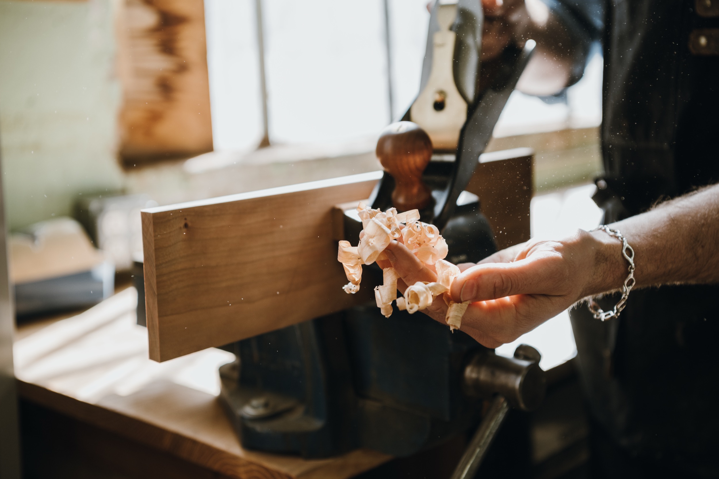 Hand plane shaving wood in the Flatow Furniture workshop