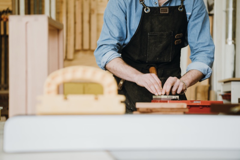 Sharpening a hand tool on a whetstone in the Flatow Furniture workshop