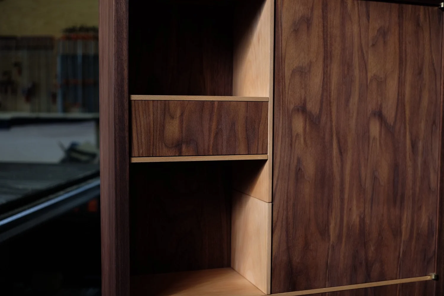 Close-up of a wooden cabinet with open shelves and closed door