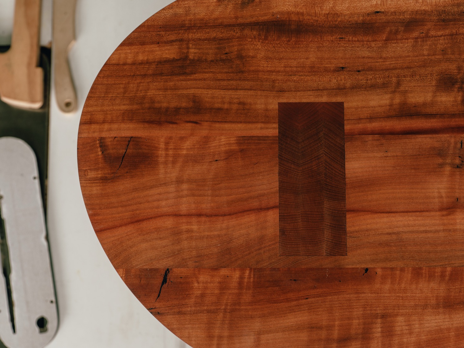 Top-down view of madrone coffee table showing walnut through-tenon and rich grain