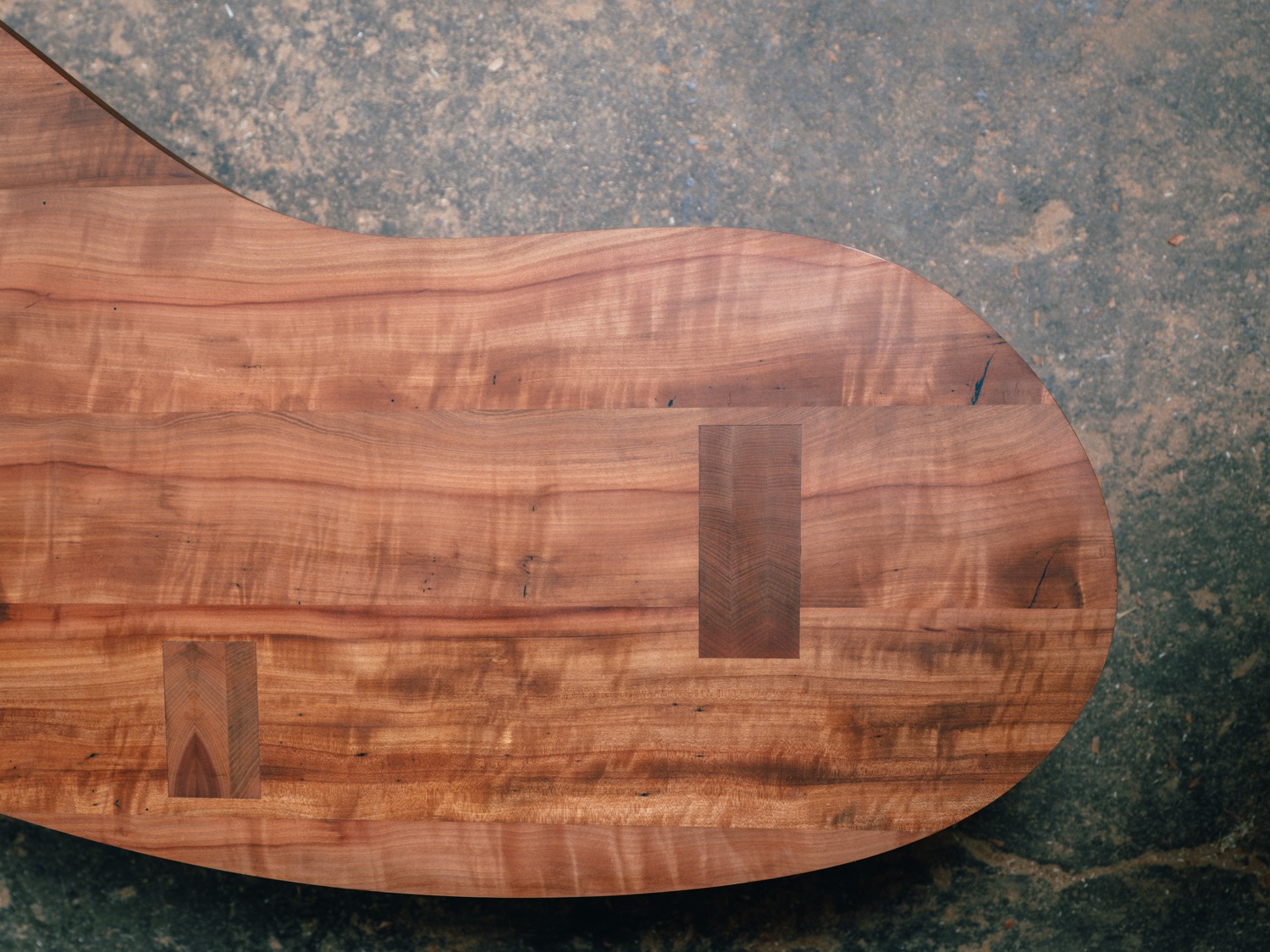 Overhead detail of madrone coffee table edge with through-tenon joinery