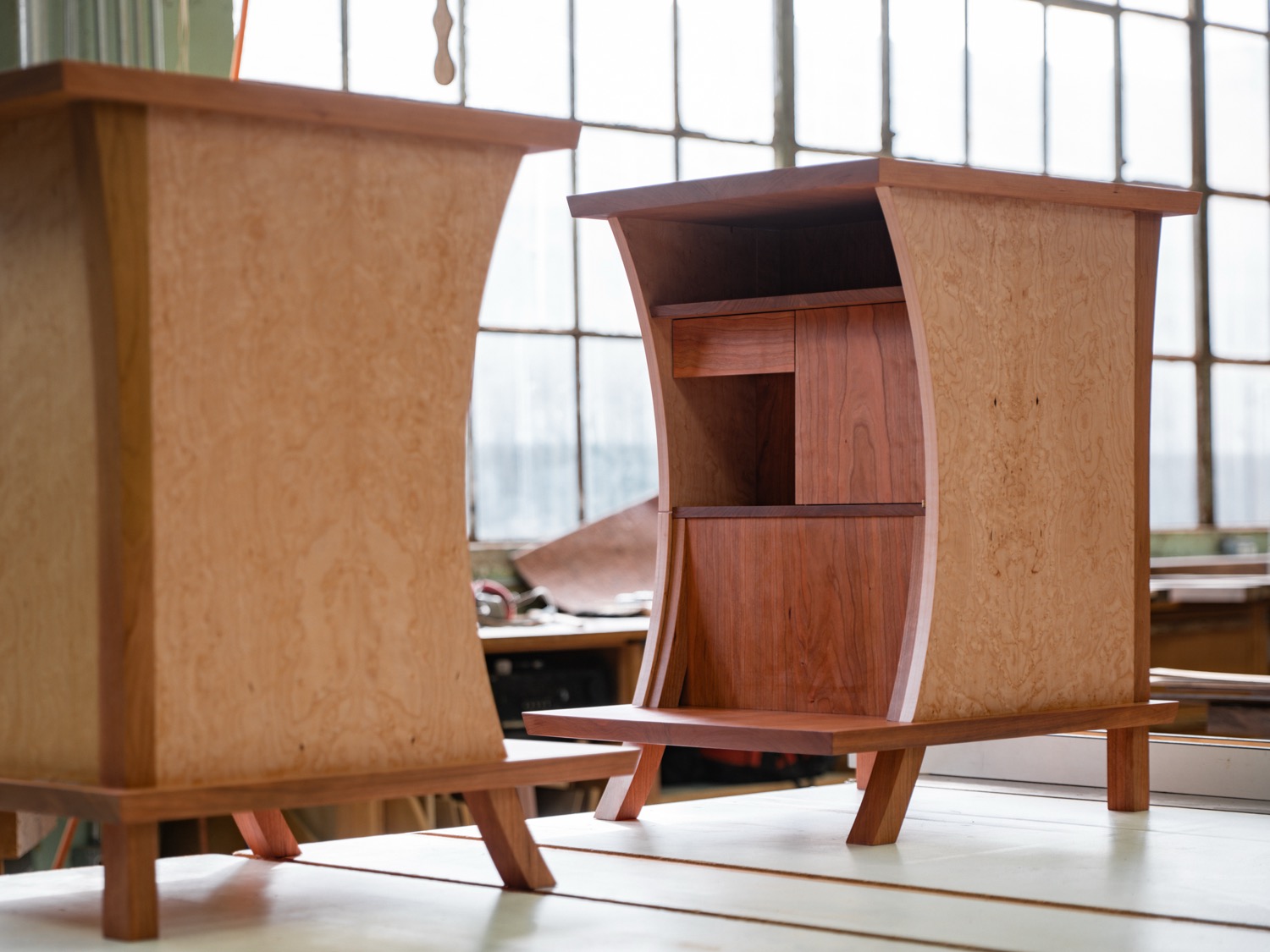 Cherry and birdseye maple nightstands showing bedside open shelving and curved maple sides