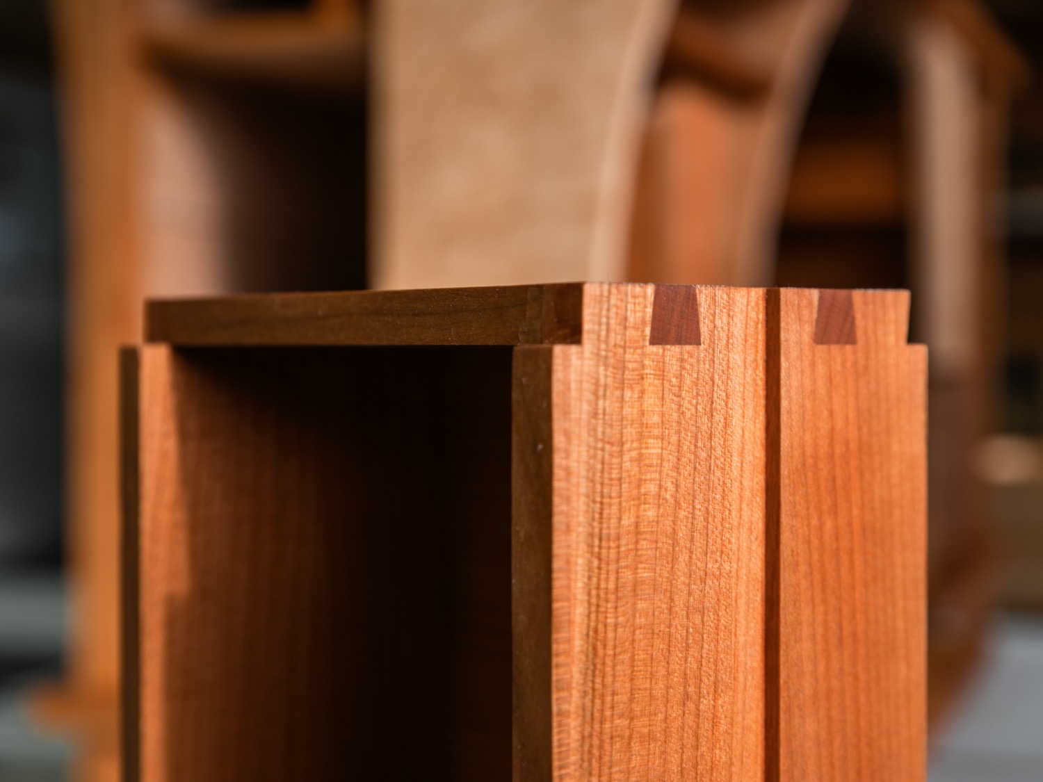 Close-up of hand-cut dovetail joinery on cherry nightstand drawer