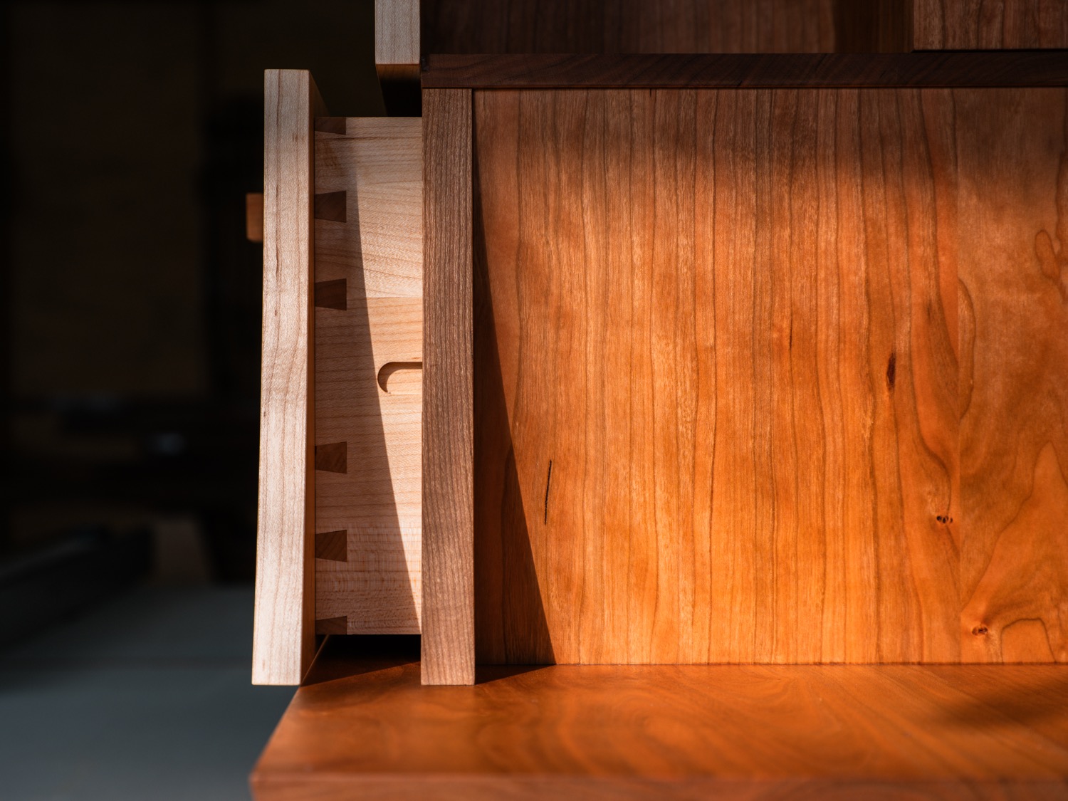Cherry drawer pulled open showing dovetail joinery detail